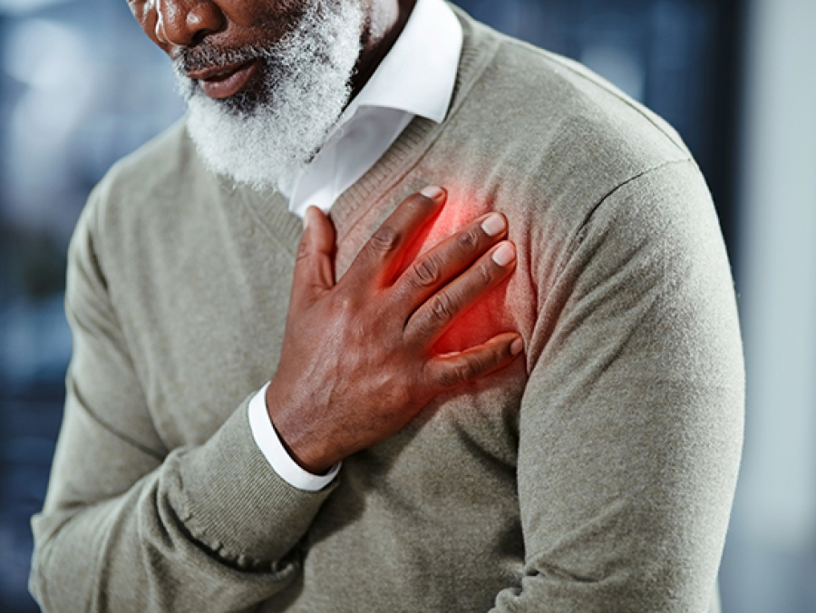 Black man in sweater holding his hand over heart with inflammation